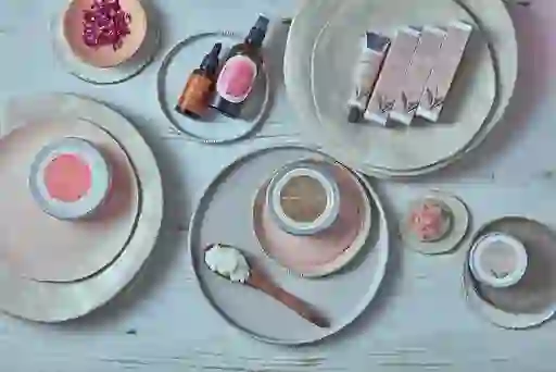 Dublin Herbalists skincare products including body scrub and oils displayed on pastel-toned ceramic plates.