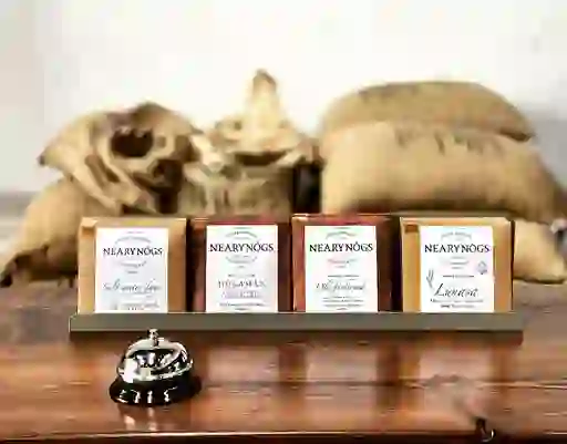 Four NearyNógs chocolate bars on a wooden counter, with hessian coffee sacks in the background.