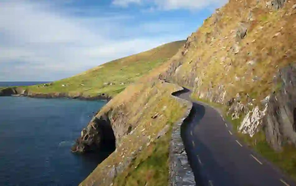 Narrow road hugging the cliffs of Slea Head with sweeping Atlantic Ocean views on the Dingle Peninsula.