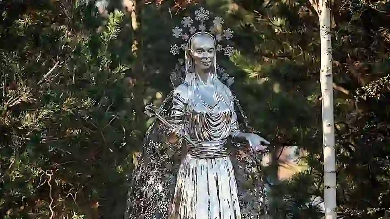 White sculpture of the White Witch surrounded by woodland at CS Lewis Square, Belfast.