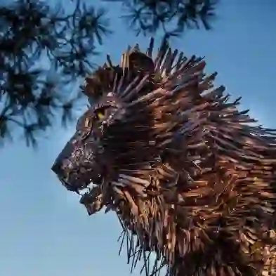 Aslan sculpture at CS Lewis Square, Belfast, made from steel plates against a blue evening sky.