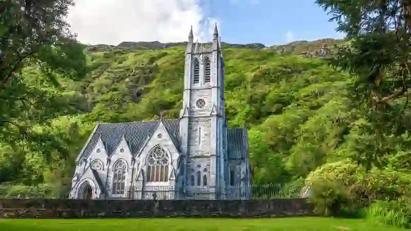 Kylemore Abbey’s Gothic church set against lush green Connemara hillside.