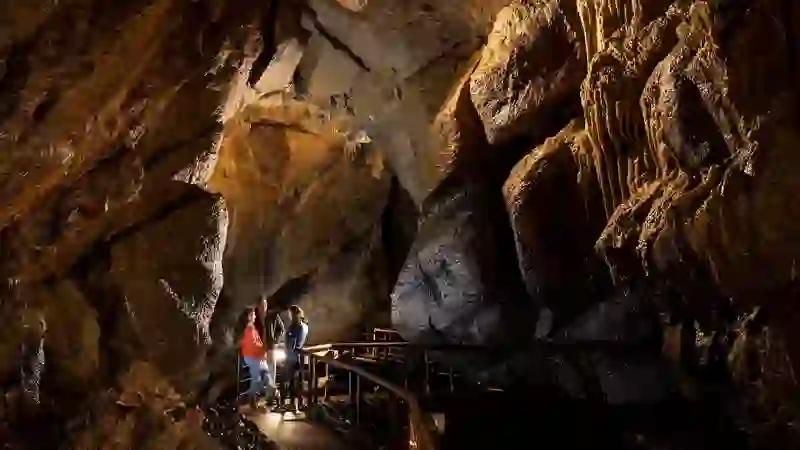 Exploring illuminated limestone chambers in Marble Arch Caves.