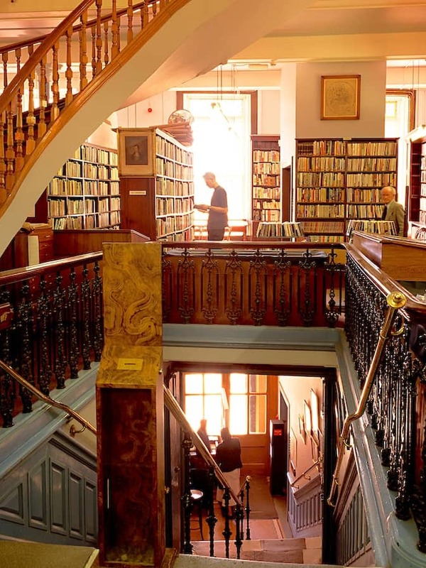 Ornate wooden staircase and book-lined galleries inside the Linen Hall Library, Belfast.