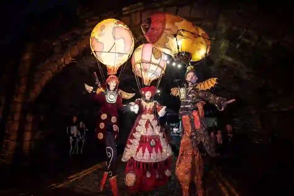 Costumed stilt performers with illuminated hot-air balloons parade through Derry~Londonderry for Halloween.
