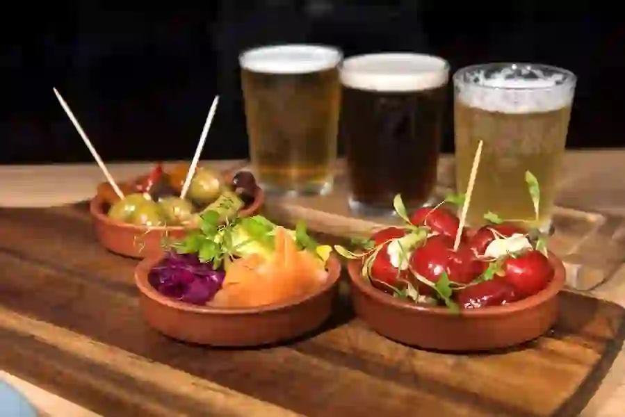 Tapas dishes with olives, peppers and salad served with glasses of beer at the Walled City Brewery, Derry~Londonderry.