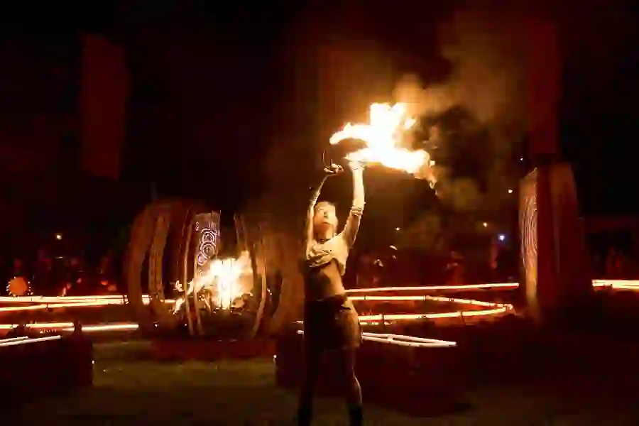 Performer raises flaming props in a dramatic fire display at the Púca Festival in County Meath.