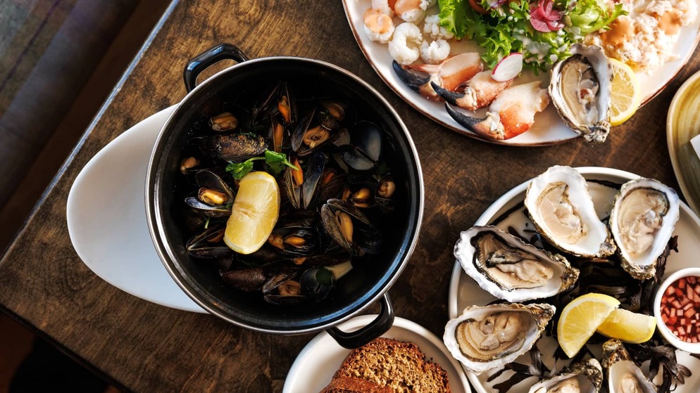 Fresh seafood spread at Monk's, County Clare, with oysters, mussels, crab and brown bread served on a rustic table.