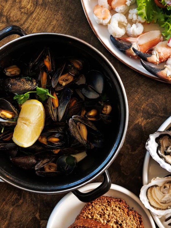 Fresh seafood spread at Monk's, County Clare, with oysters, mussels, crab and brown bread served on a rustic table.