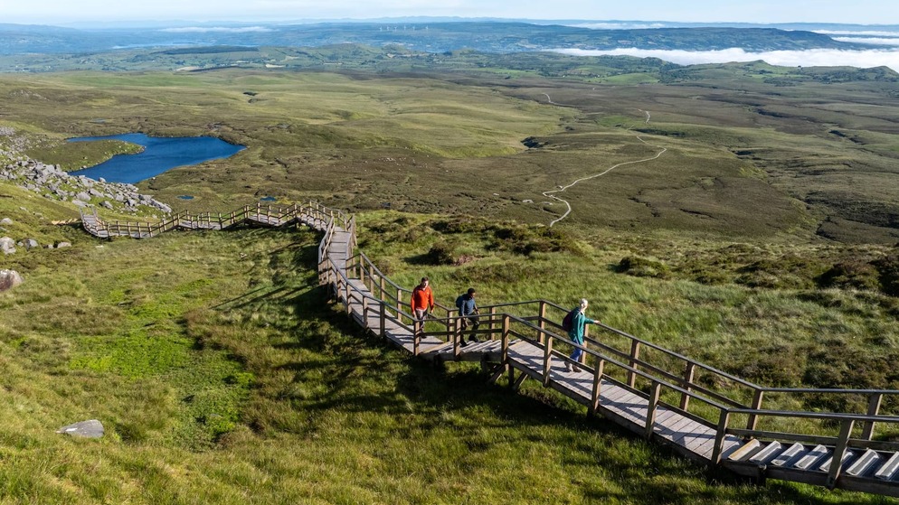 Walkers explore the Cuilcagh Boardwalk Trail amid sweeping upland scenery in County Fermanagh.