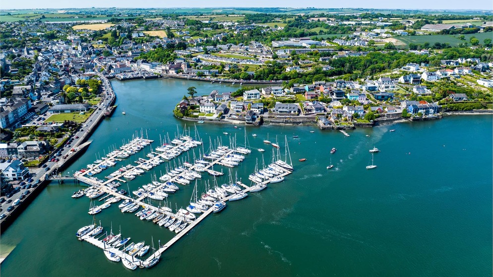 Aerial view of Kinsale Harbour and marina in County Cork, with yachts and colourful waterfront buildings.