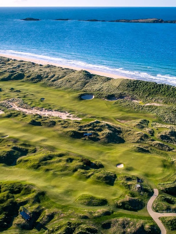 Aerial view of Royal Portrush Golf Club with rolling links fairways overlooking the Atlantic Ocean.
