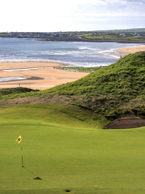 Golf green surrounded by towering sand dunes at Lahinch Golf Club in County Clare.
