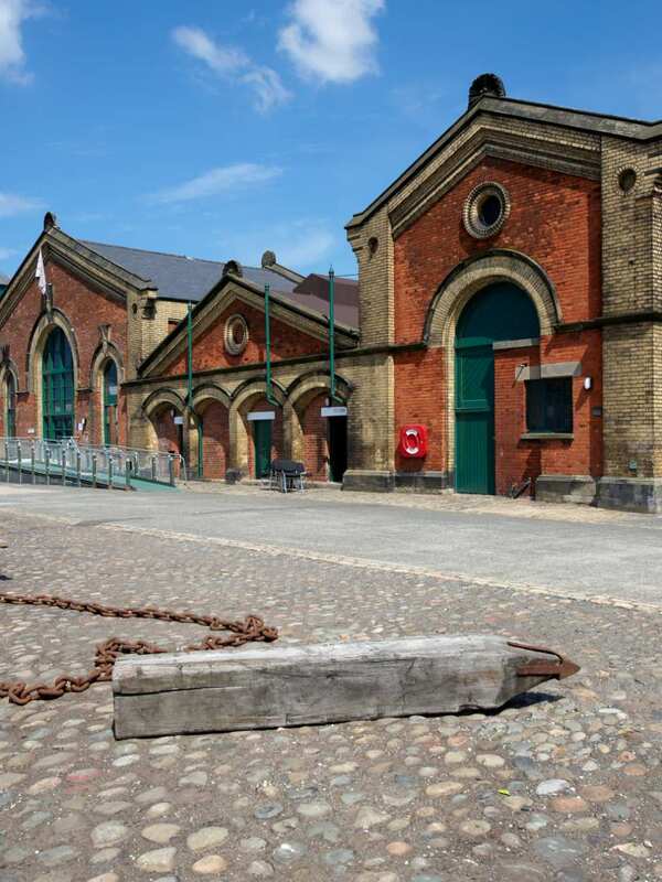 Historic red-brick Harland &amp; Wolff building at Titanic Quarter in Belfast on a sunny day.