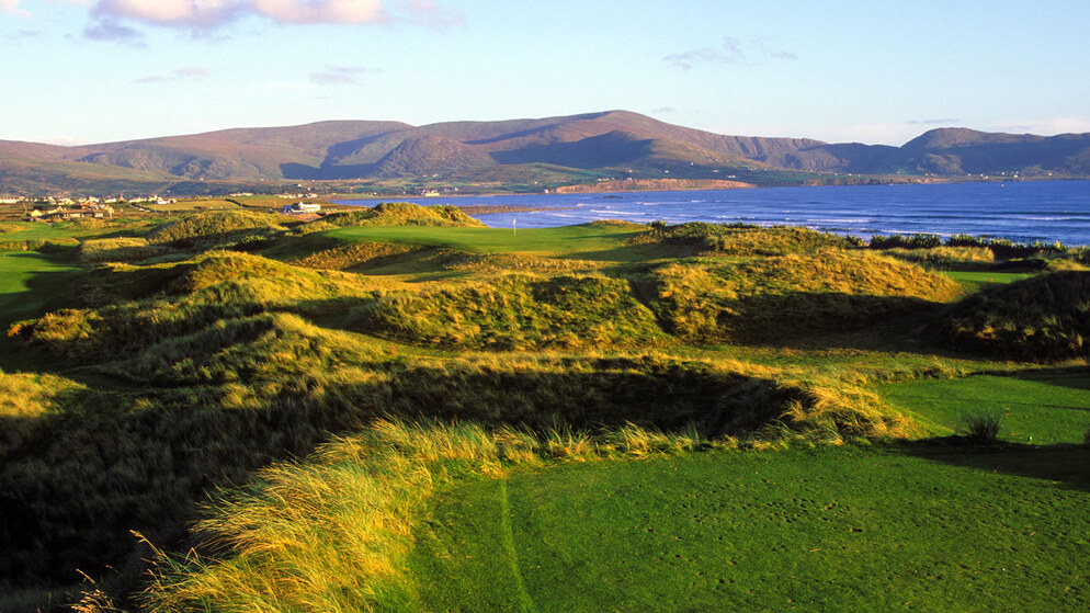Coastal golf course in Ireland with Atlantic views and rugged mountain backdrop.